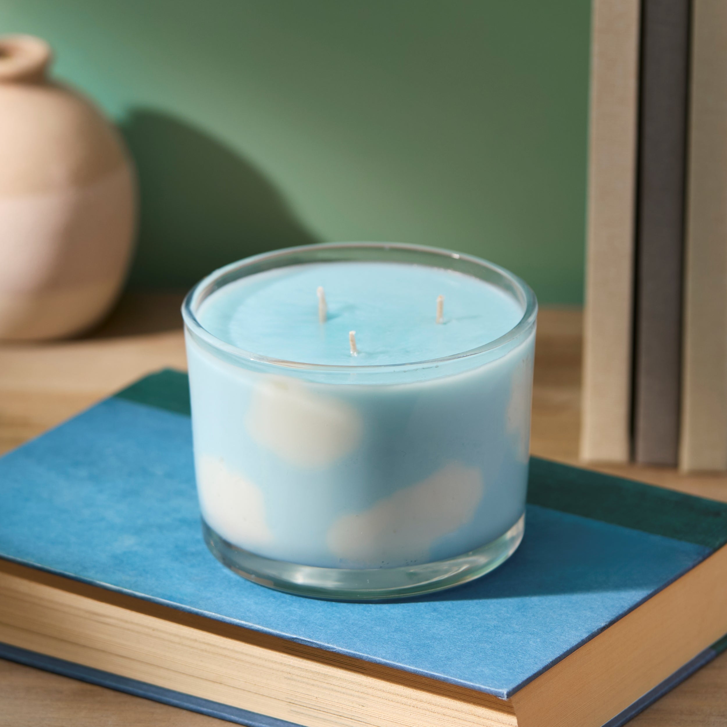 cloud candle sitting on a book