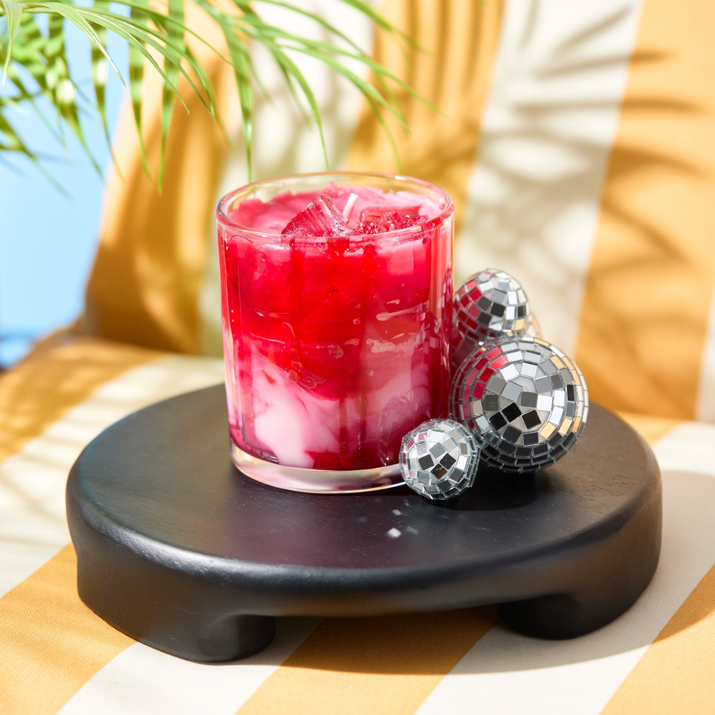 death by daiquiri candle next to small disco balls