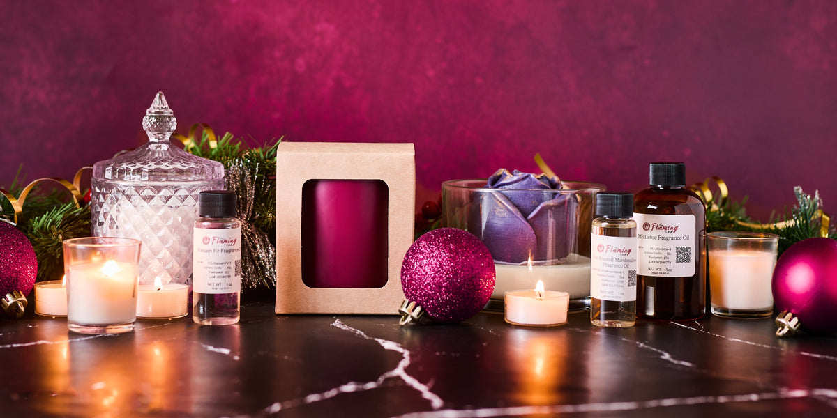 Decorative setup with candles, bottles, and ornaments on a dark surface against a pinkish-purple background.
