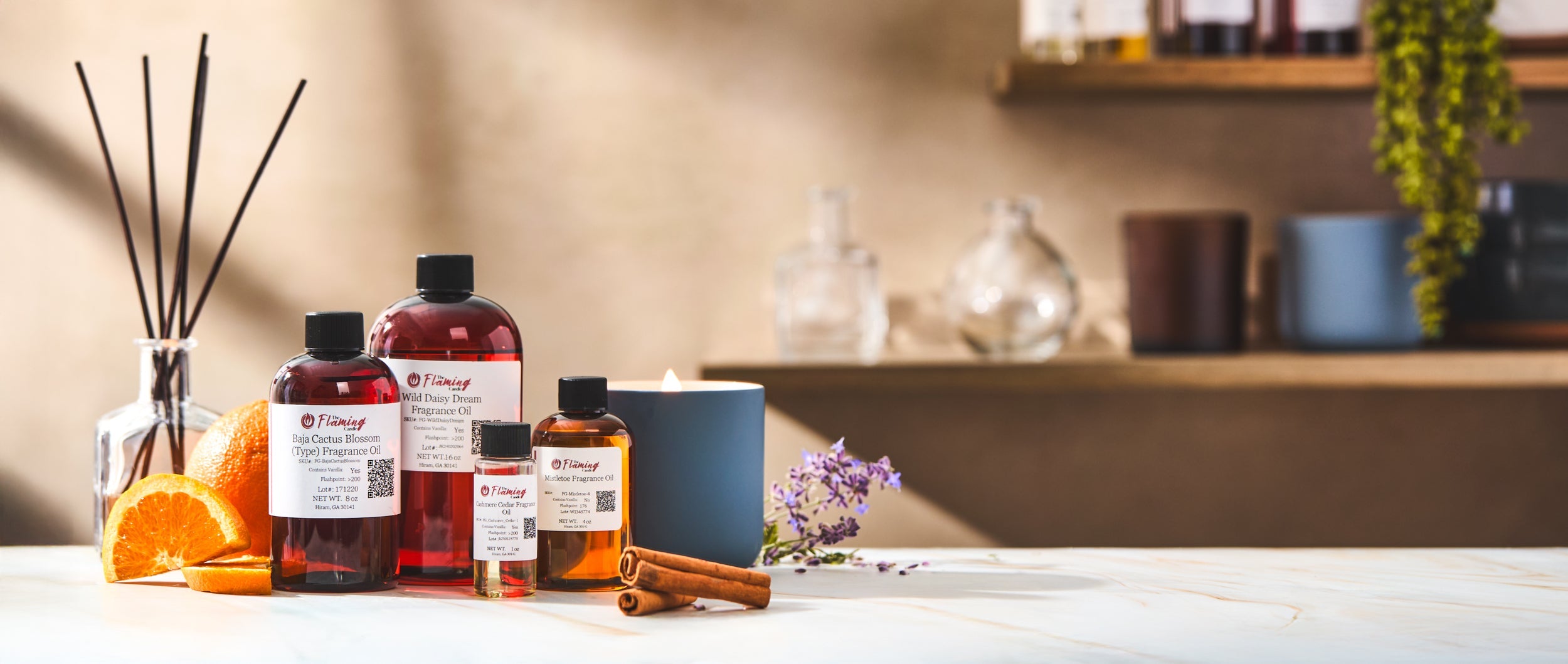 ChatGPT said:  Bottles of The Flaming Candle fragrance oils with sliced oranges, cinnamon sticks, and lavender on a marble surface beside a lit candle. Shelves with jars and plants create a warm, inviting studio atmosphere.