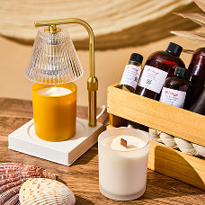 Summery beach-themed scene featuring The Flaming Candle “Bum Bum (Type)” fragrance oils with condensation, a yellow candle, pink wax melts, coconut, sunglasses, and palm leaves on sand against a golden background.
