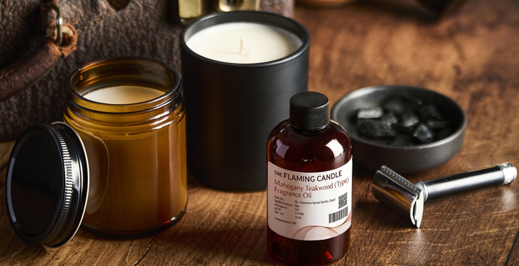 Vintage leather travel case with shaving brush, razor, candle, and grooming products arranged on a wooden table in warm moody lighting.