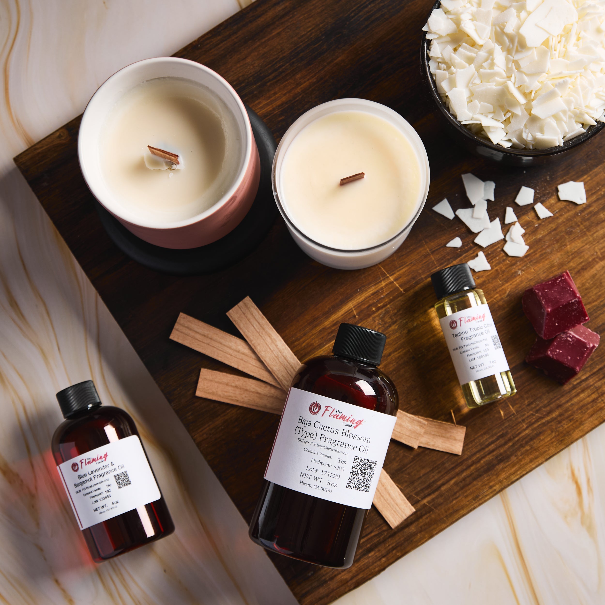 Candle-making supplies including candles, coconut pieces, and essential oils on a wooden board.